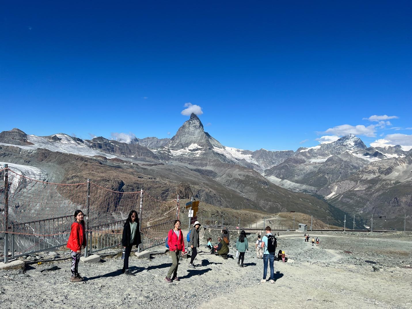 A group of people standing on a mountain

Description automatically generated