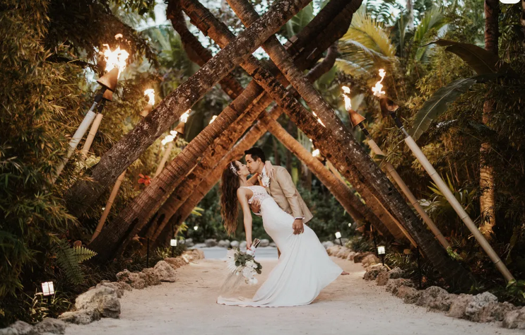 Bride and groom embrace amidst palm trees at the Cheeca Lodge & Spa in Islamorada, FL