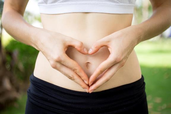 A person making a heart with her hands on her stomach

Description automatically generated