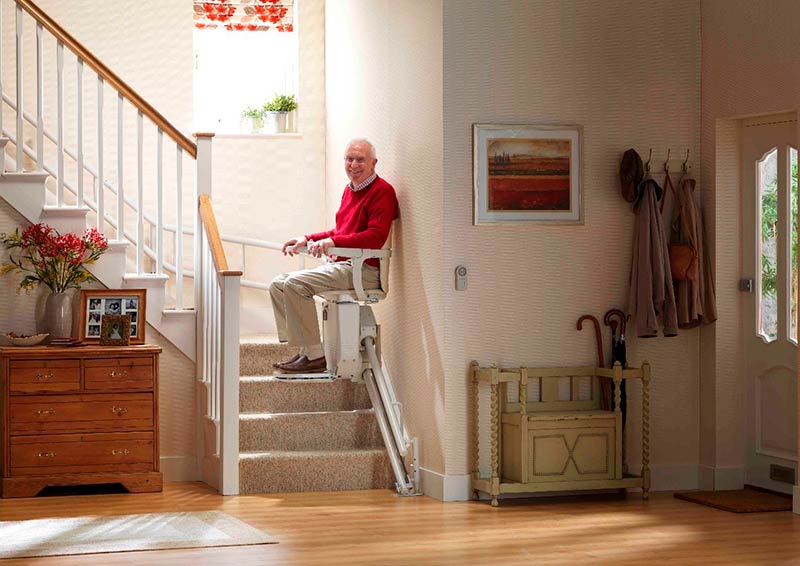 A gentleman using a curved Stannah stairlift