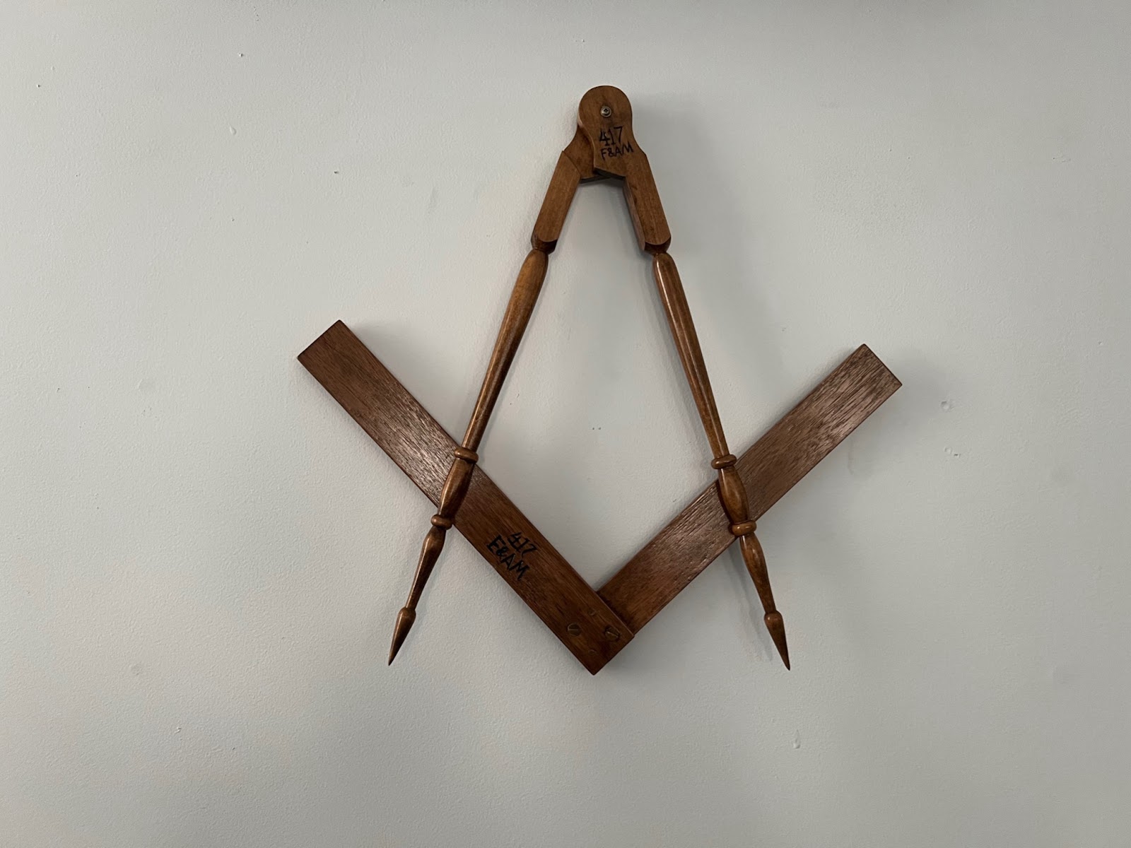 An image of the Masonic square and compass symbol.