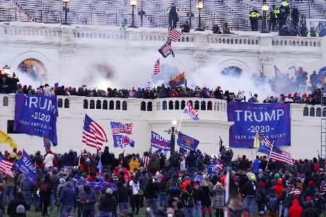 A crowd of people with flags and smoke

Description automatically generated
