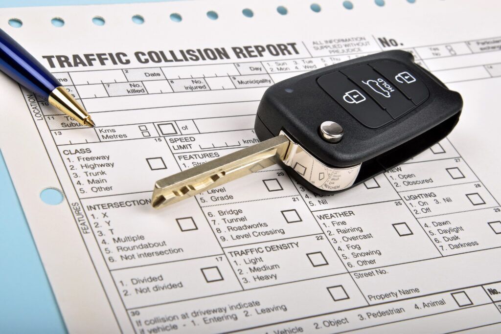traffic car accident report with car keys on it