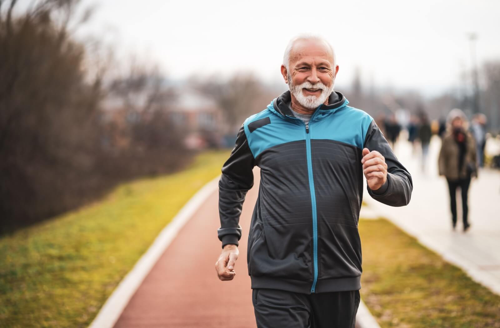 A happy older adult man jogging.
