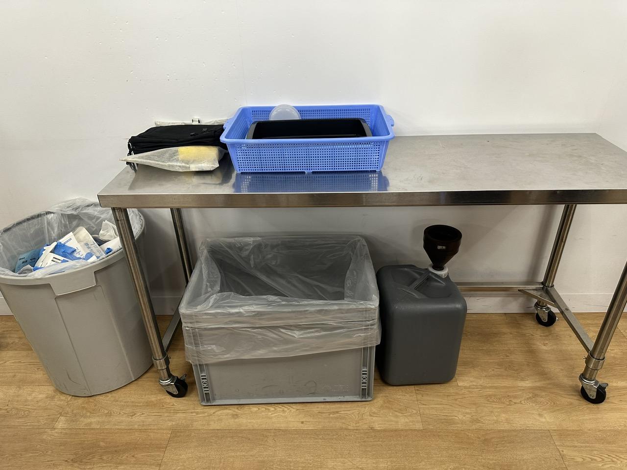 A metal table with a cart and binsDescription automatically generated