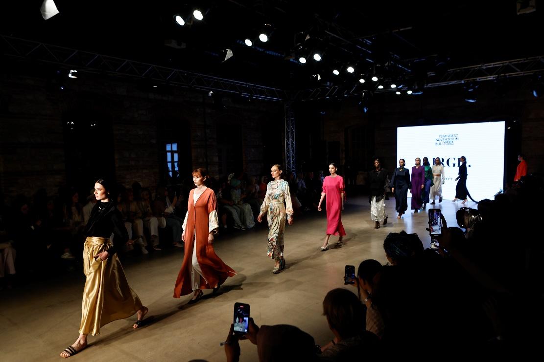 A group of women walking on a runway

Description automatically generated