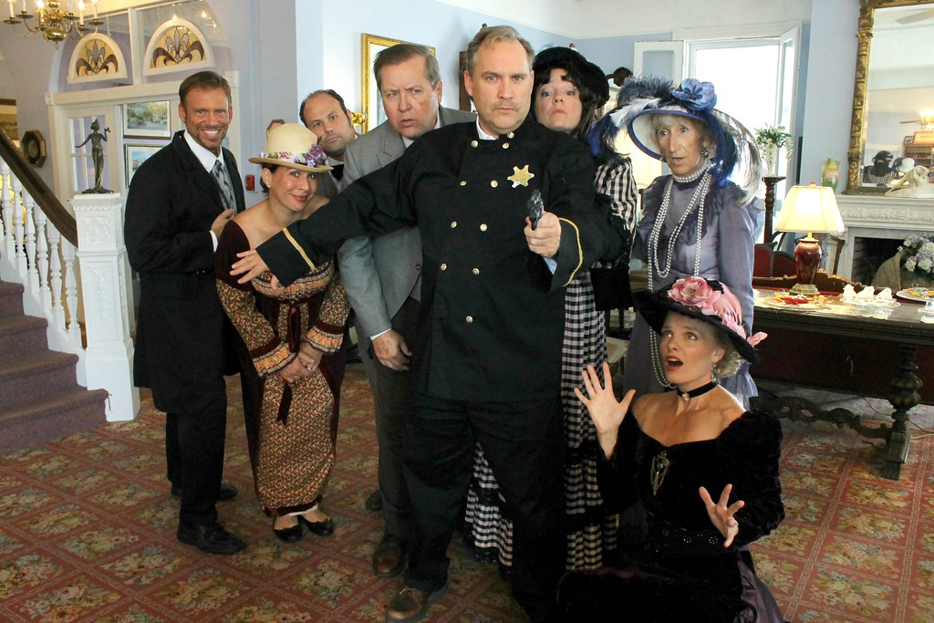 A group of people in costumes having murder mystery dinner. 