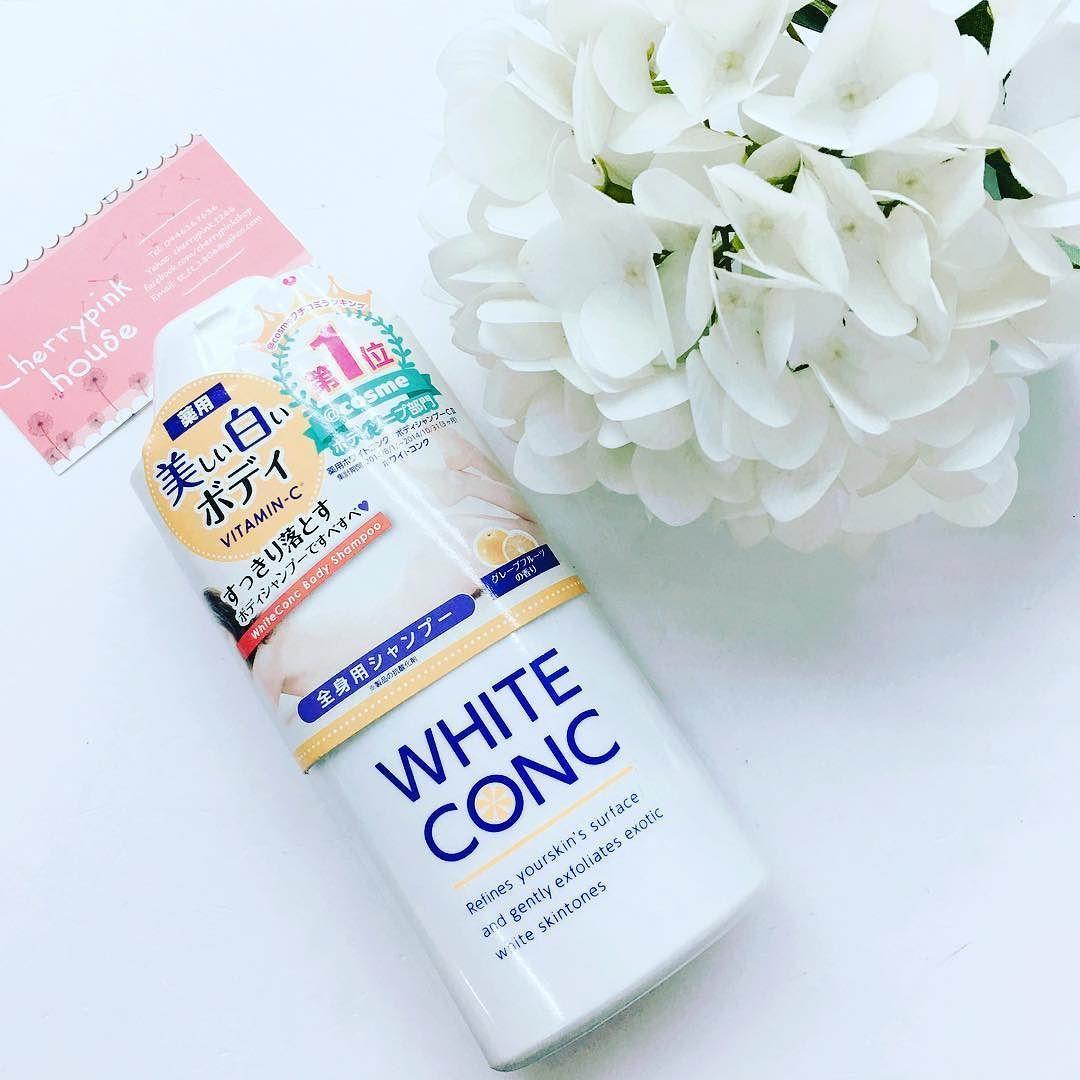 A white bottle next to a white flower

Description automatically generated