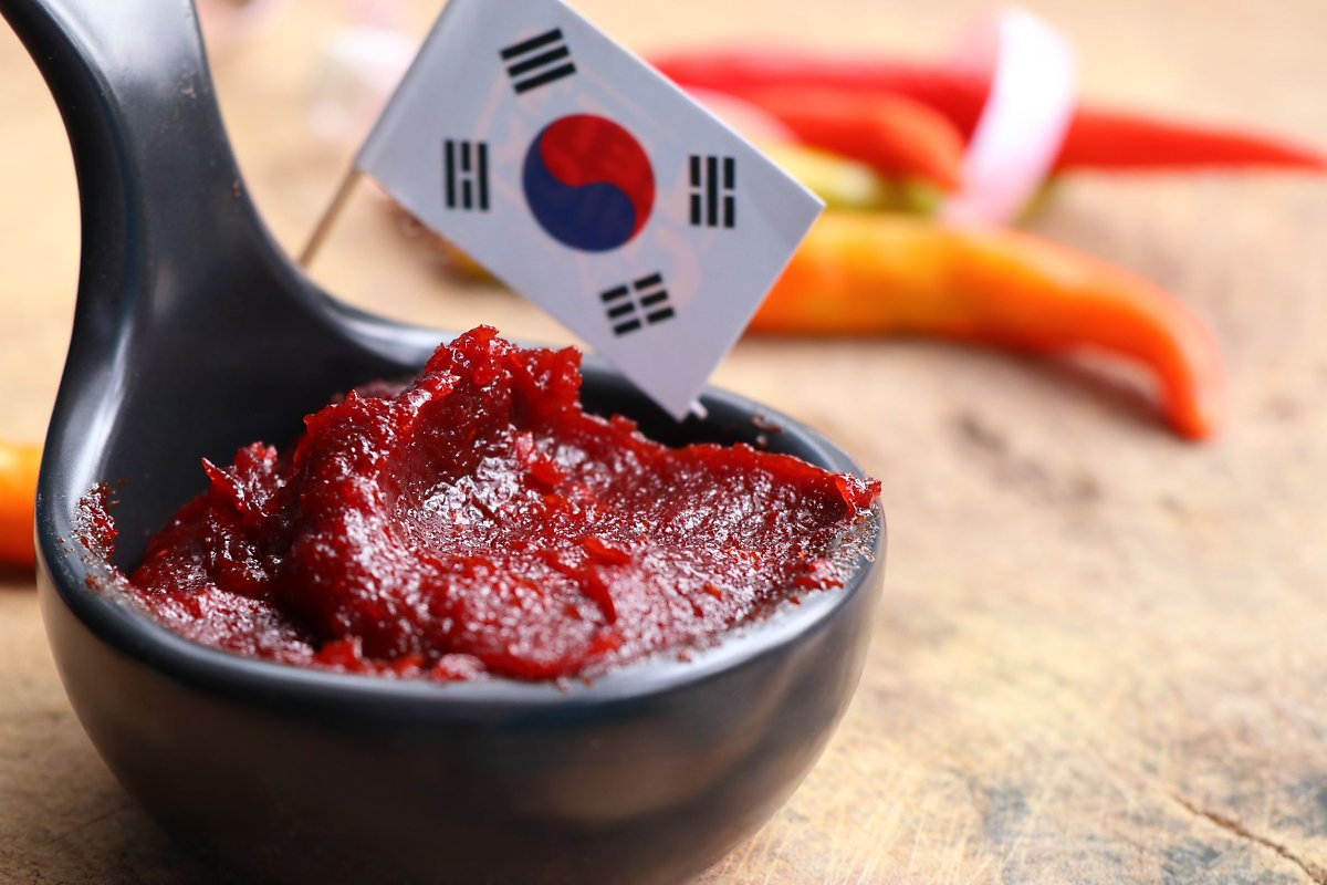 A bowl of red sauce with a flag on top

Description automatically generated
