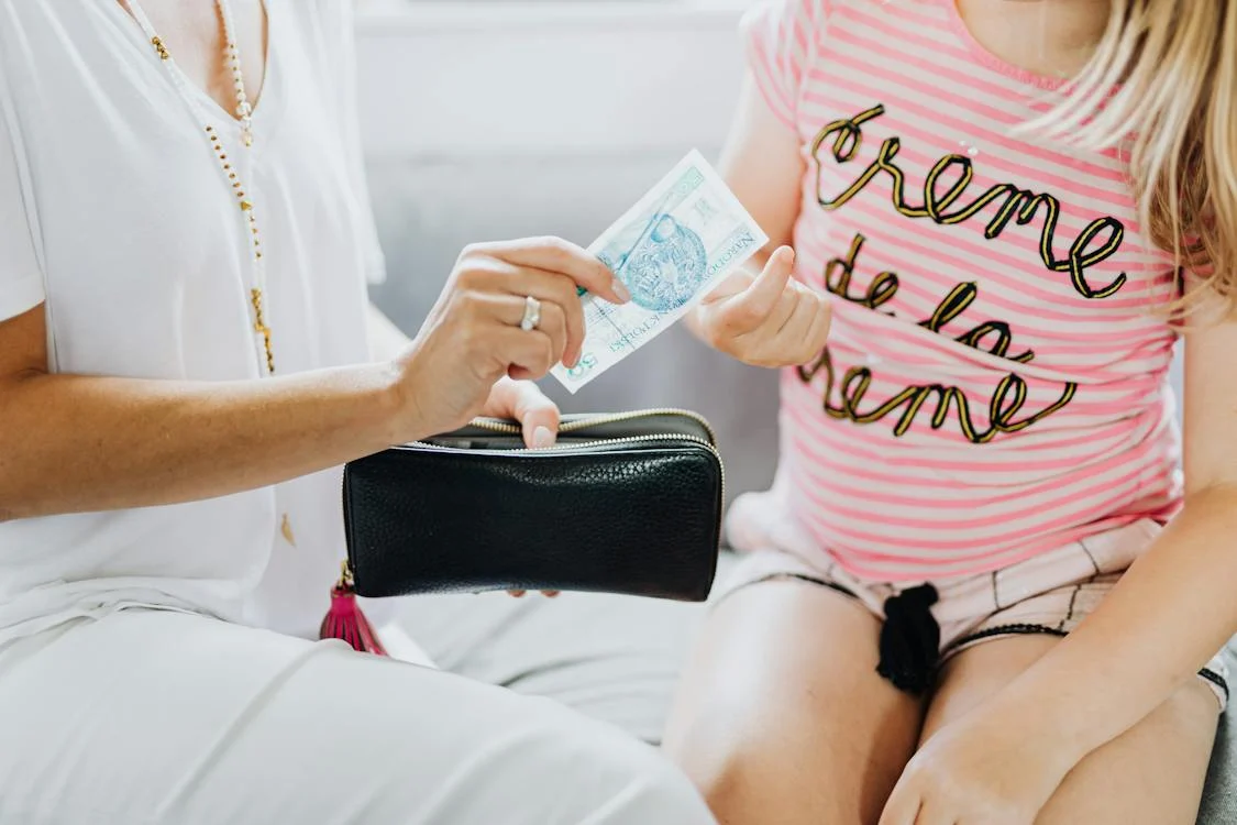 A mother giving her child some money