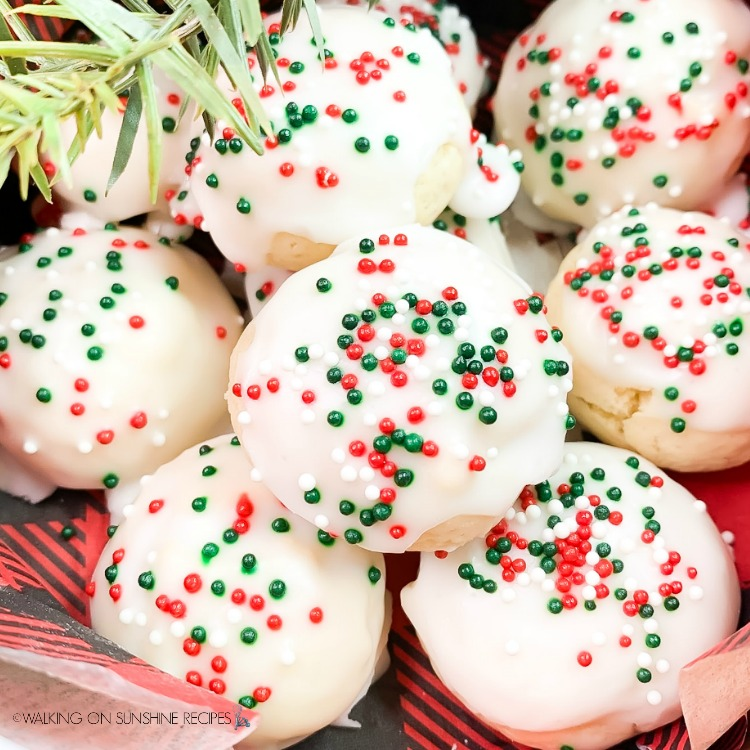 lemon italian christmas cookies with white icing and christmas sprinkles 
