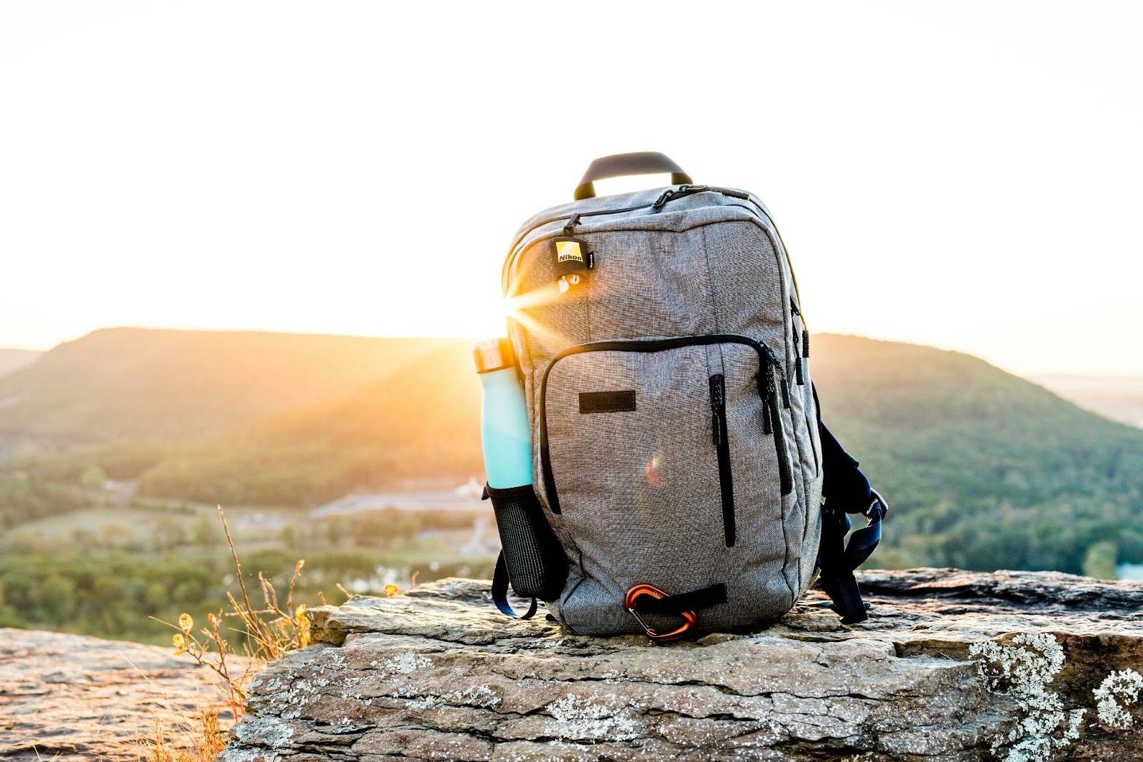a backpack on a rock with the sun shining behind it, highlighting that staying safe while hiking depends on being prepared