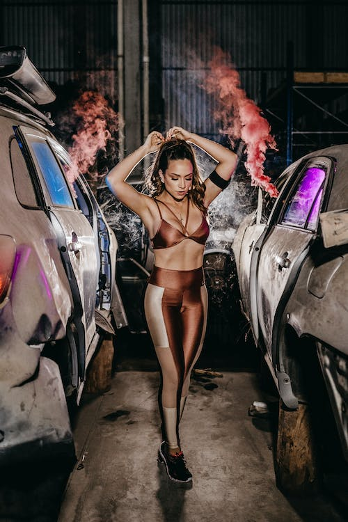 Sexy Girl in A Sassy Pose Between Two Cars