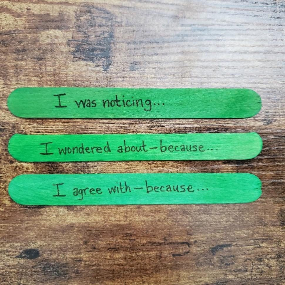 A group of green popsicle sticks with writing on them Description automatically generated with medium confidence