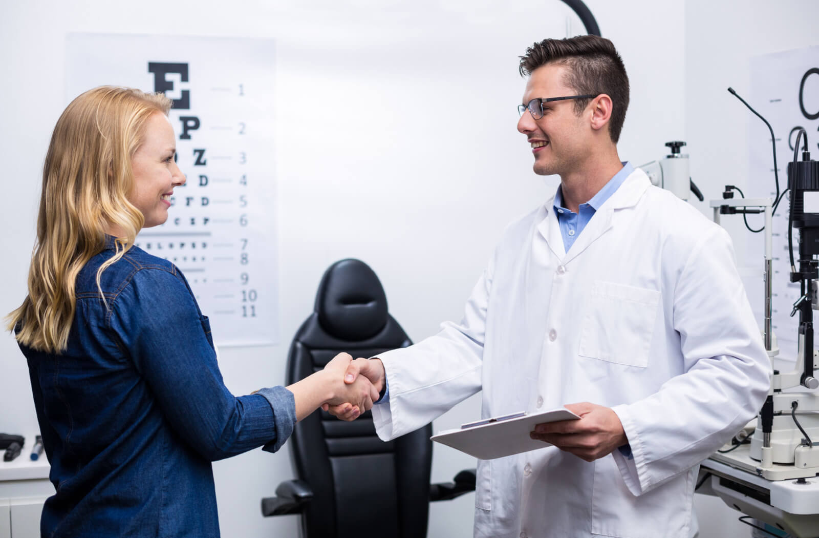 An optometrist and his patient shakes hands.
