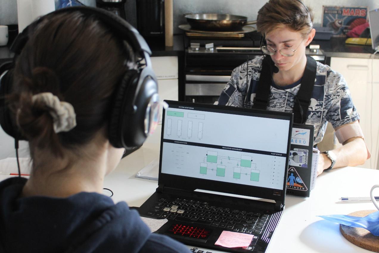 A person wearing headphones looking at a computer Description automatically generated