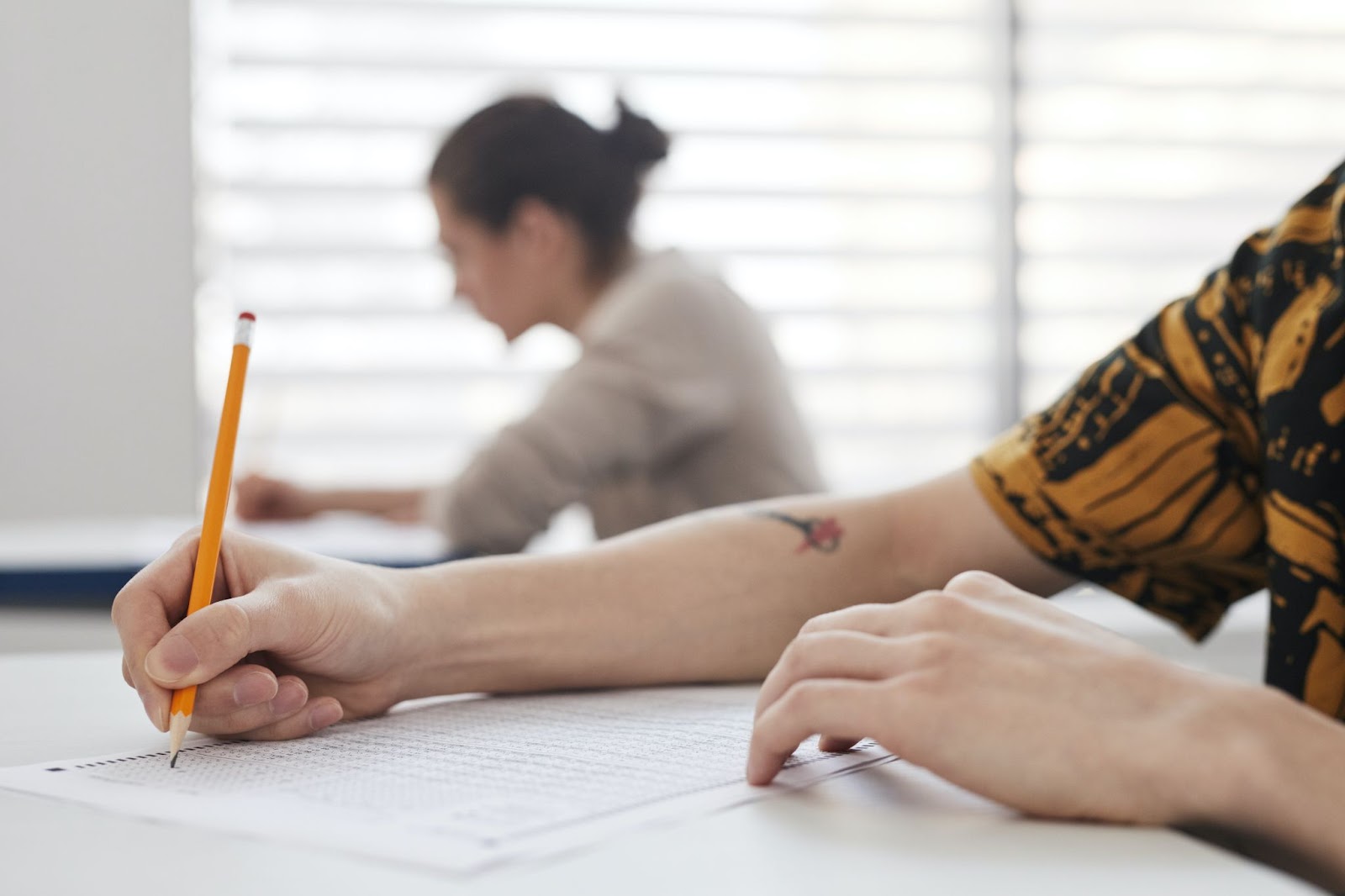 IELTS writing test being completed by a student after gaining IELTS tips. 