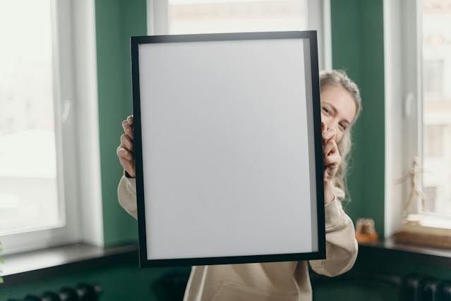 women holding a large picture frame
