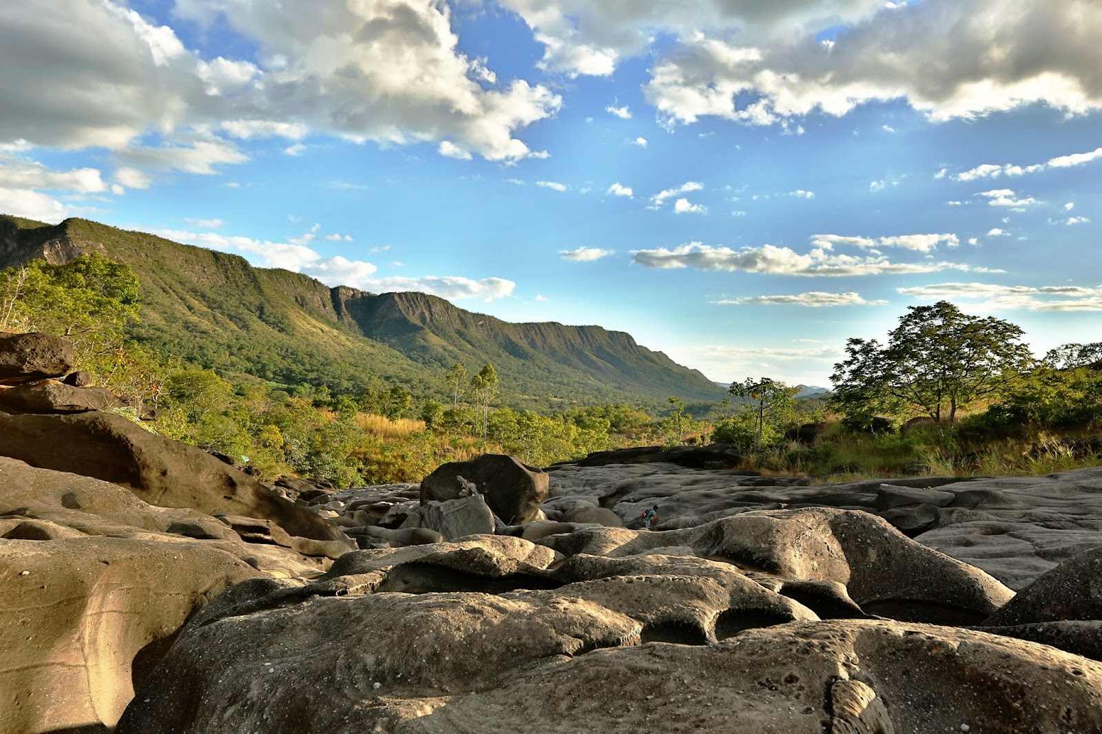 Vale da Lua na Chapada dos Veadeiros. Formação rochosa lisa em foco, com grande chapada ao fundo.