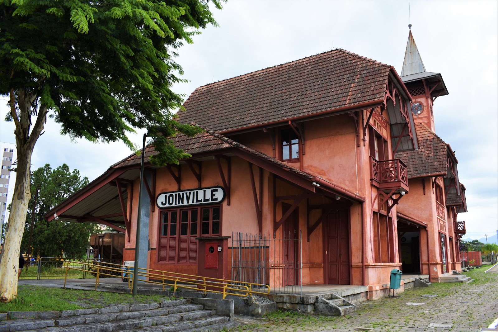 Antiga estação de Trem de Joinville. A construção de estilo enxaimel tem paredes alaranjadas, telhados íngremes e muitos detalhes em madeira escura.