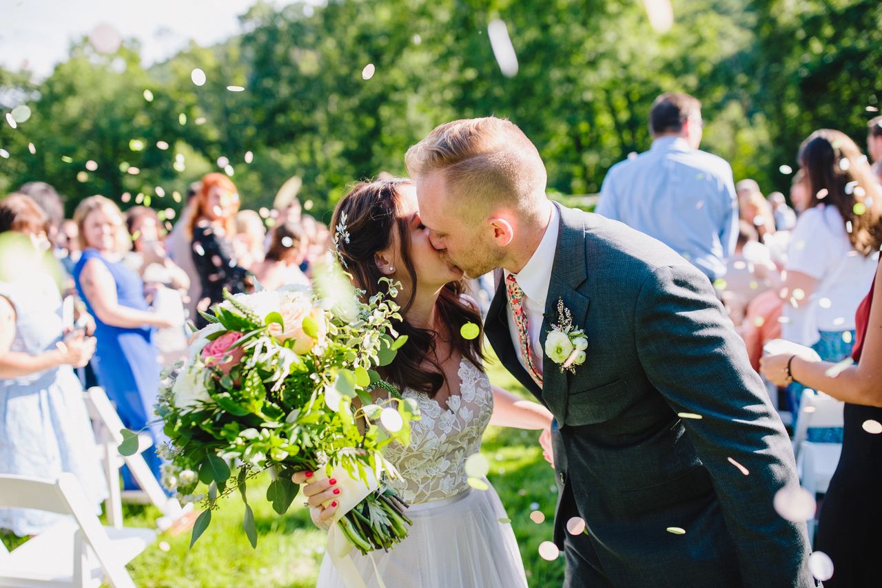 Bride and Groom kissing at end of aisle