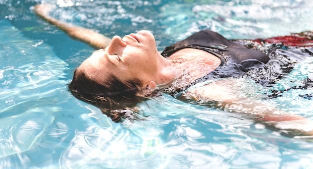 Free photo woman enjoying the water in a swimming pool