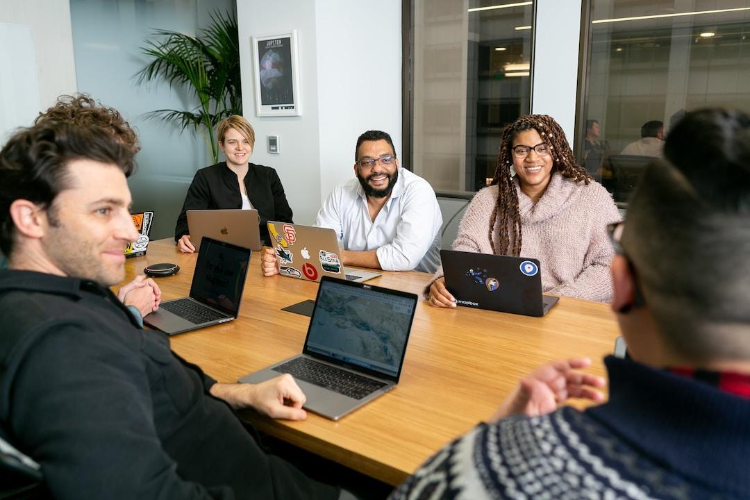 A team sitting at a table with laptops discussing revenue leakage