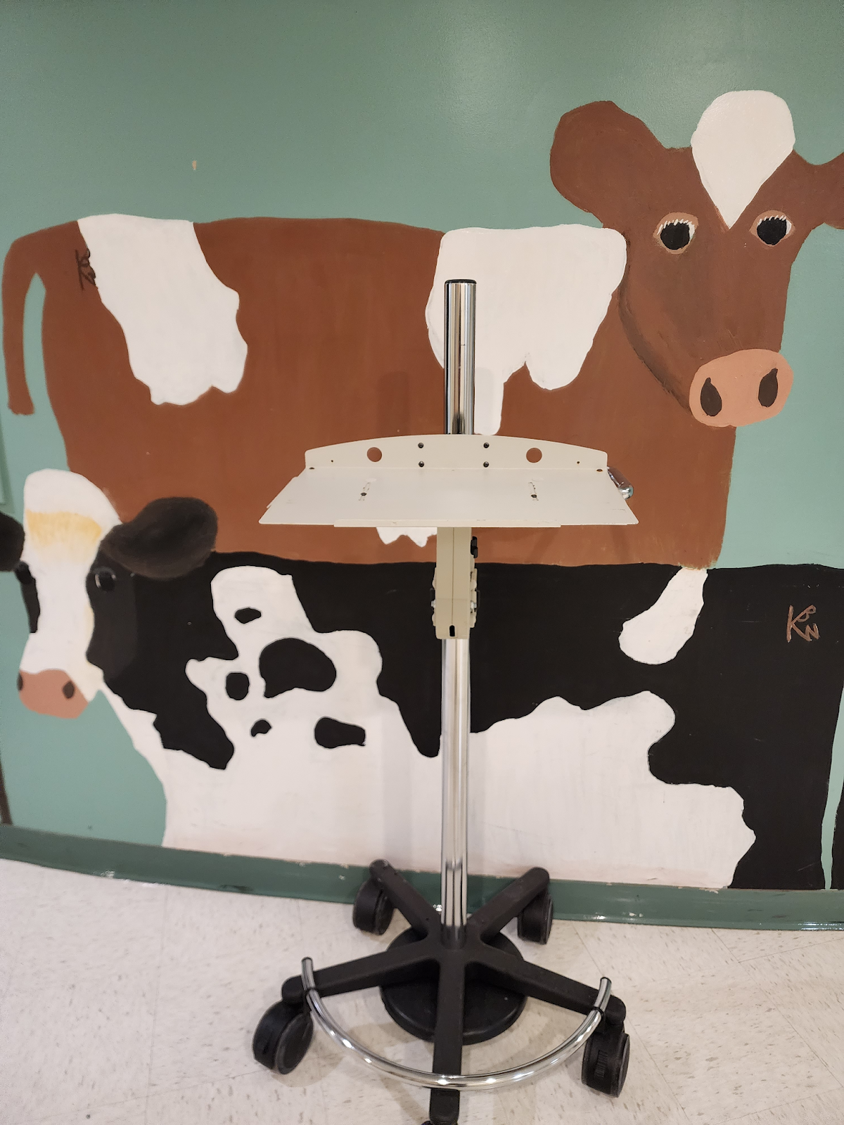 cows painted on the wall, rolling laptop cart in front of the cows