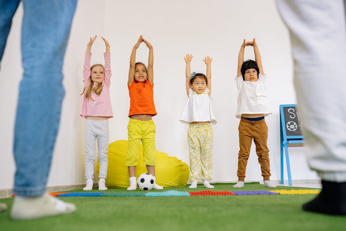 Free Three Girls And A Boy Doing Exercises At School Stock Photo