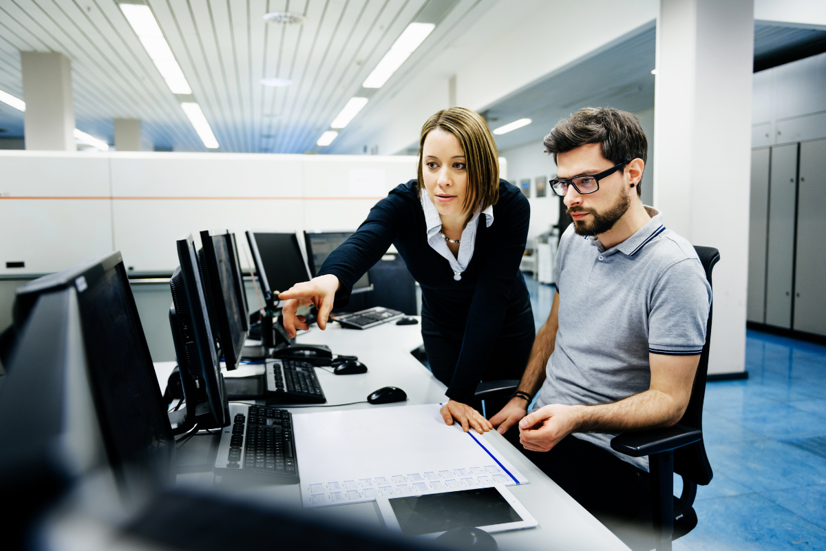 imagem ilustrativa com 2 profissionais em frente a computadores fazendo parte da alocação de profissionais de TI  