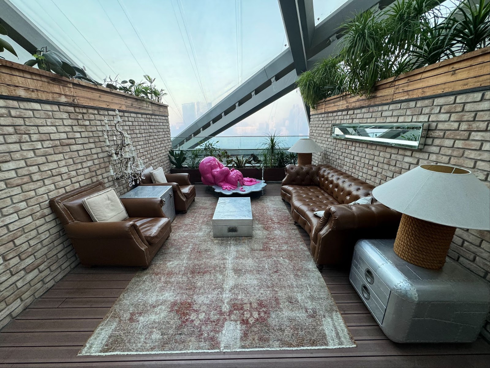 Our private terrace connected to our hotel room featuring a leather sofa, a view of Beijing, and abstract art