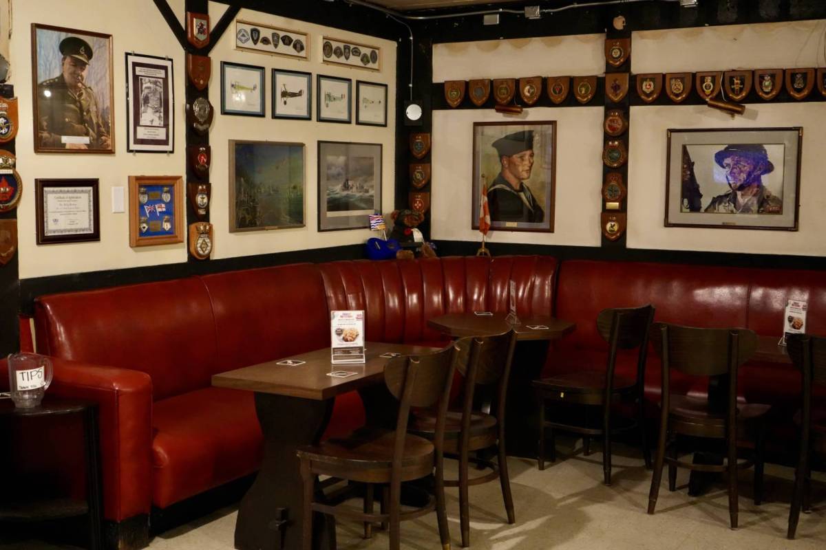 The interior of Kitsilano Leion, with photos of servicemen on te walls and red leather booths.