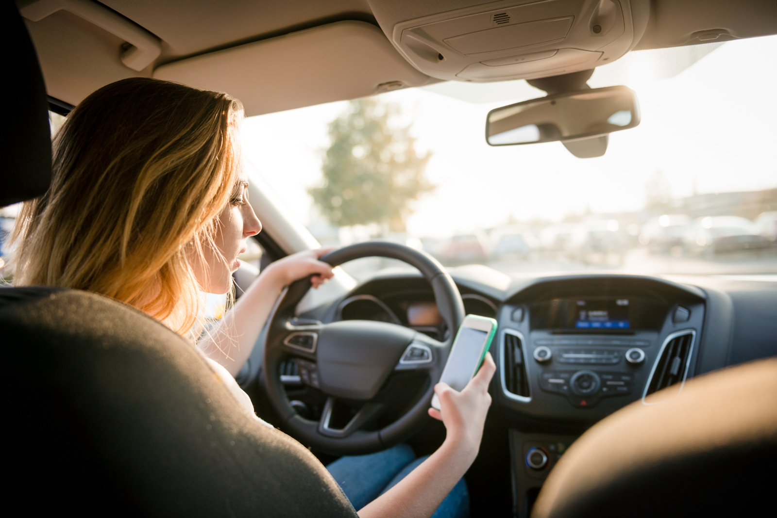 woman texting while driving, not practicing safe driving