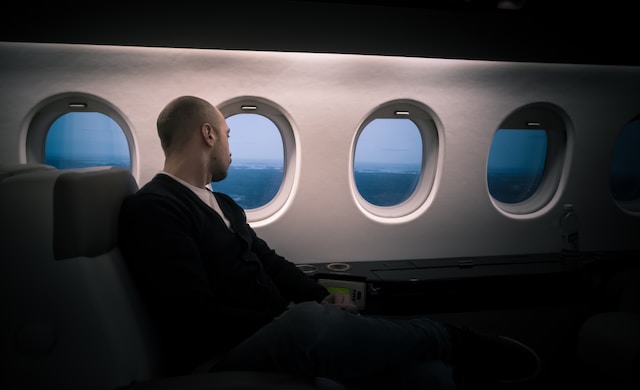 Man looking out airplane window in first class