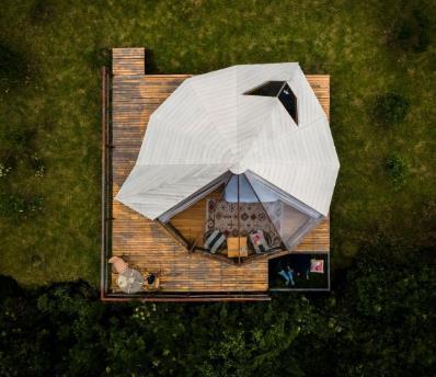 A dome shaped house on a wood deck

Description automatically generated