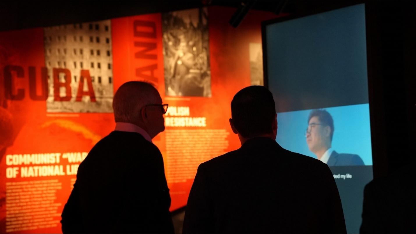 A group of men looking at a screen

Description automatically generated