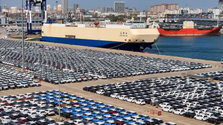 A large ship in a port with cars