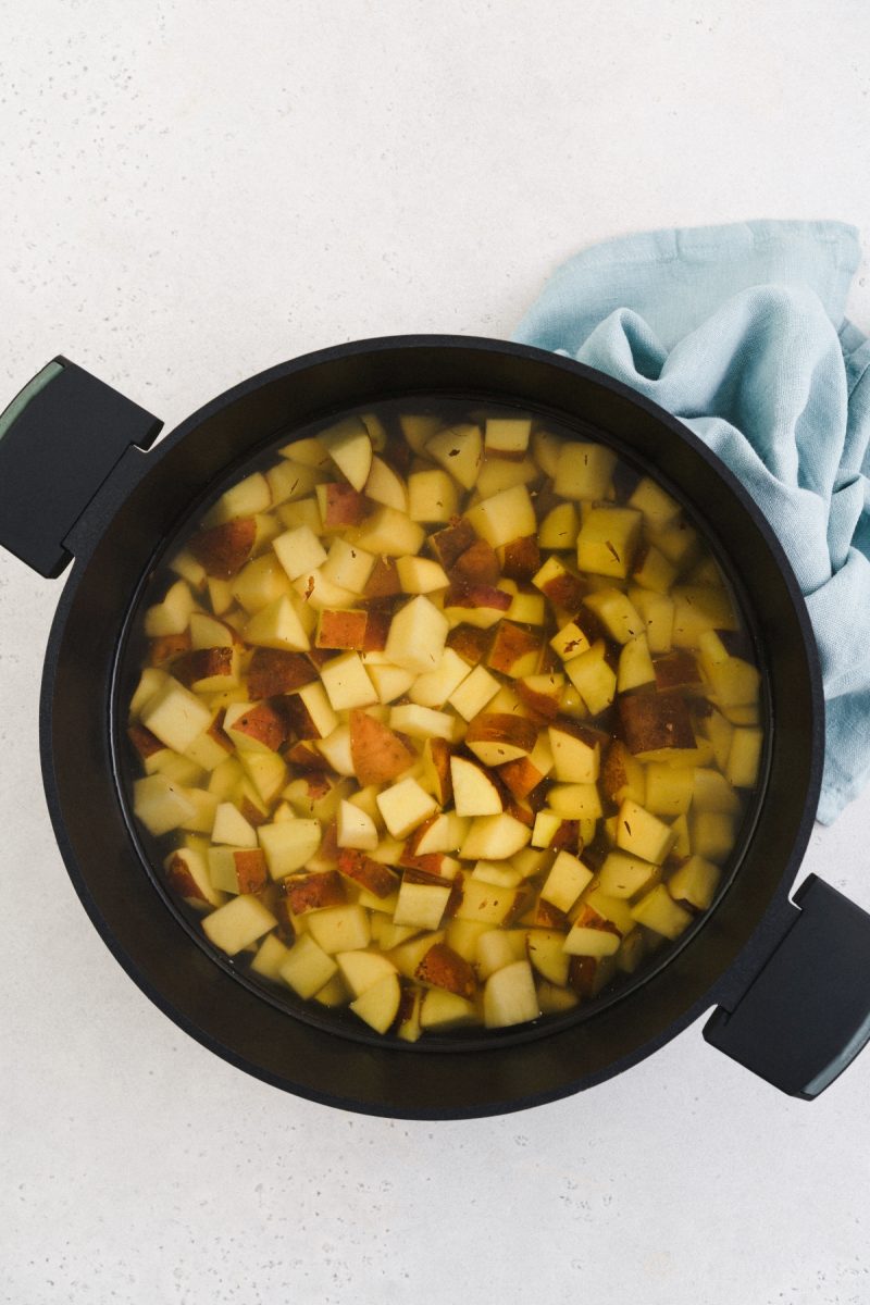 A pan with apples in it on a white surface.