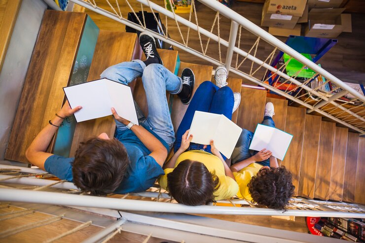 Teens reading on a staircase.