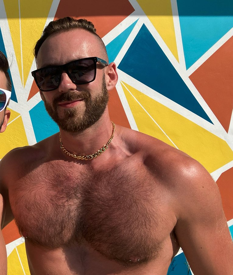 Scott Lazarus smiling shirtless outside in WeHo showing off his hairy chest and nipple ring