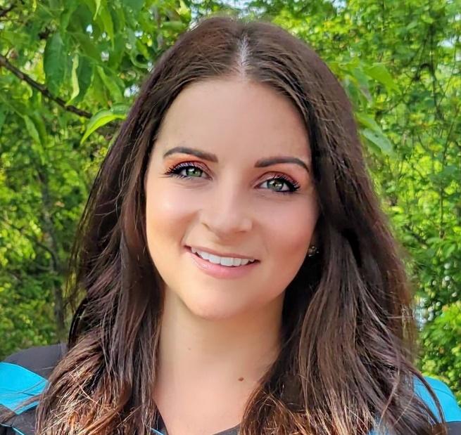 A person smiling at the camera

Description automatically generated