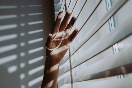 Free A Person Holding a Pearl Necklace Near the Window Stock Photo