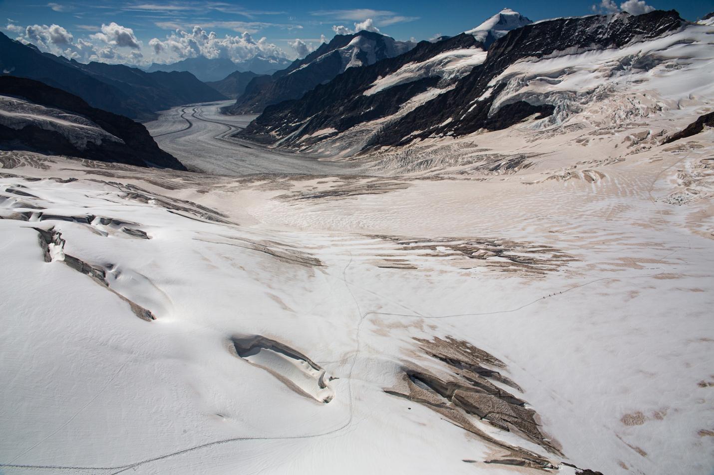 A snowy mountain landscape with a river

Description automatically generated