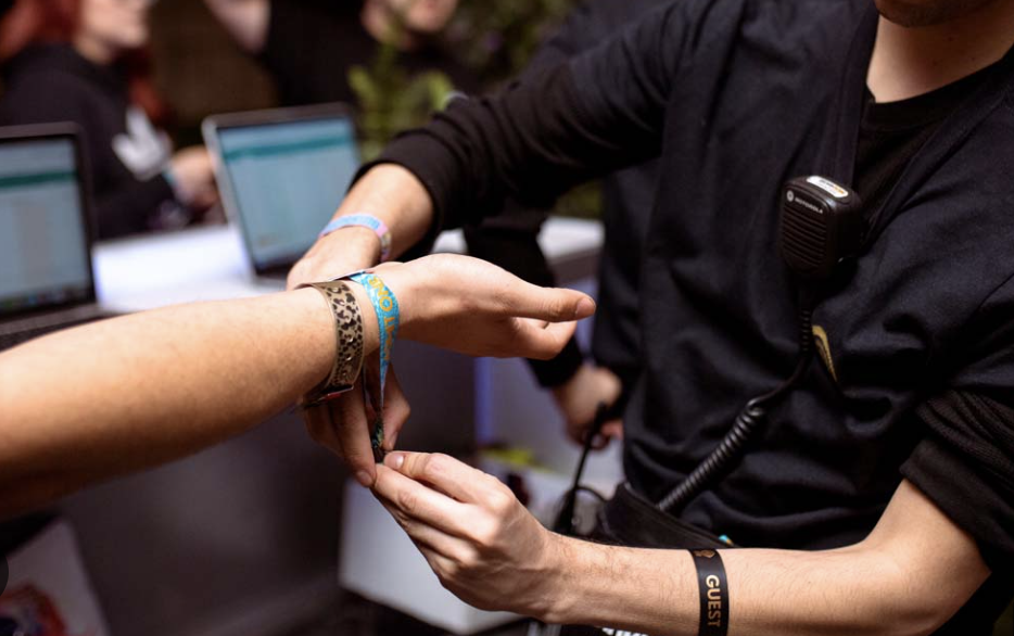 A person handing a bracelet to another person

Description automatically generated