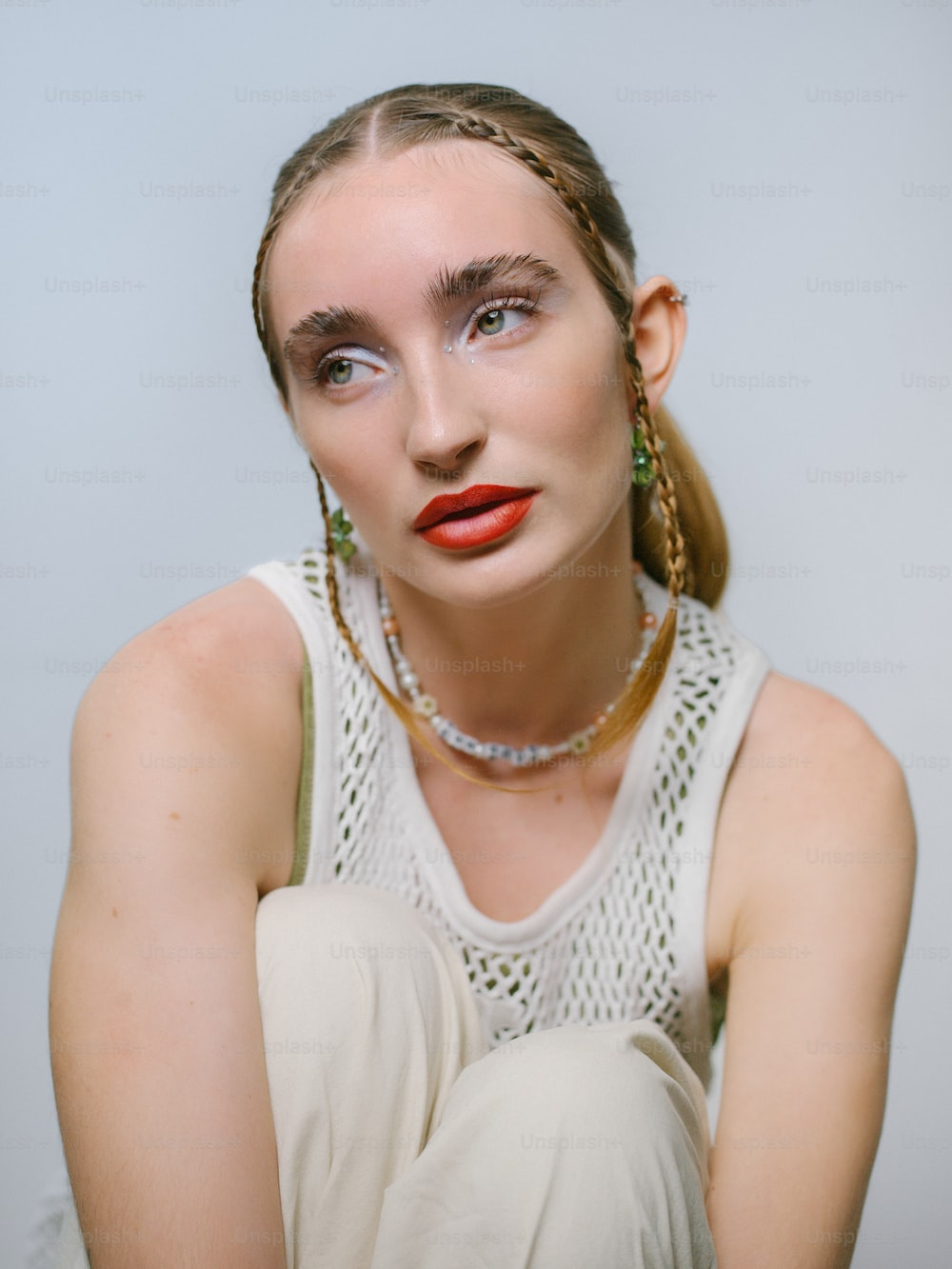 headshot of a model wearing a white tank top and whimsical makeup