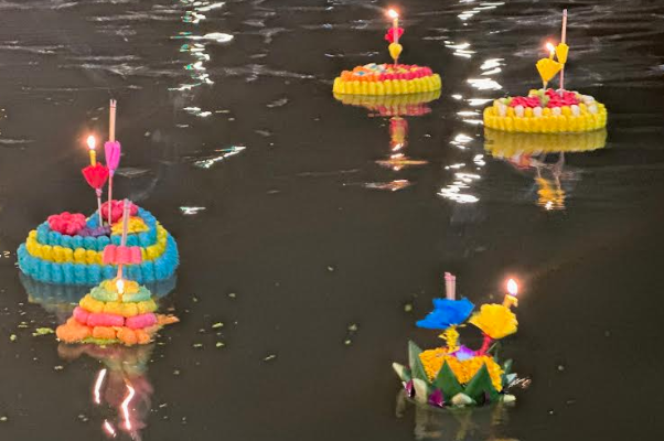 A group of floating candles in water

Description automatically generated