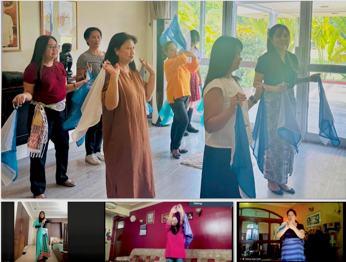 A group of women holding a blue scarfDescription automatically generated