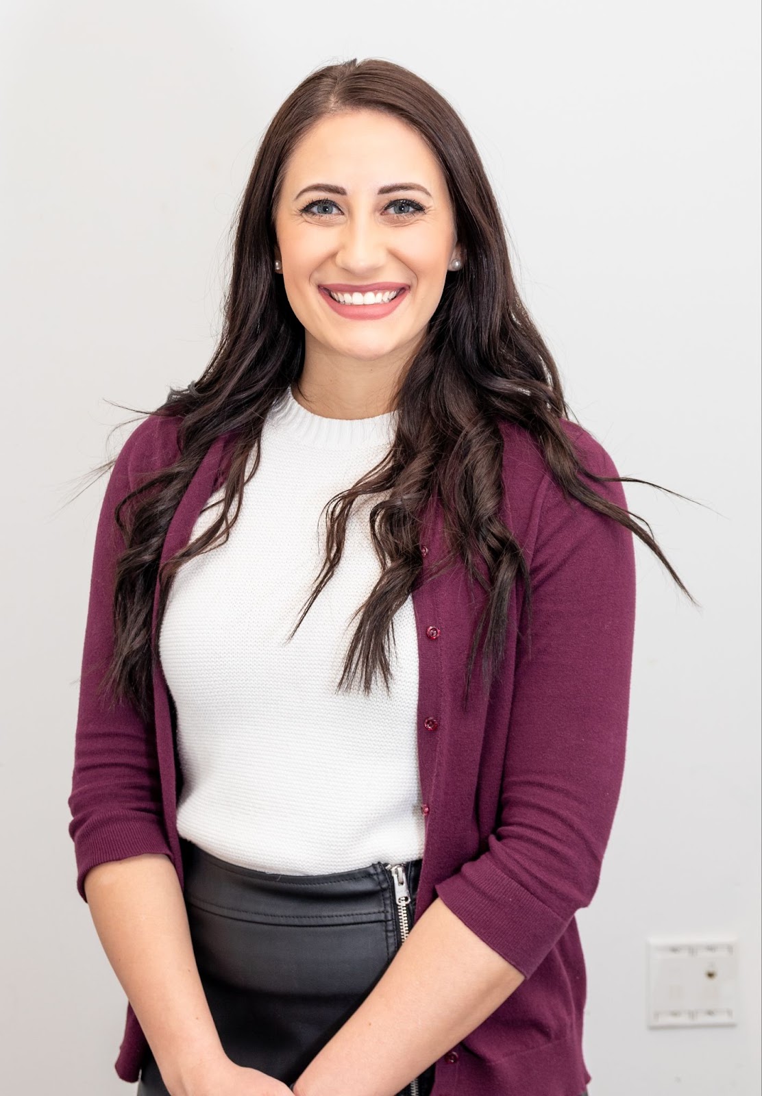 headshot of a woman wearing a plum cardigan