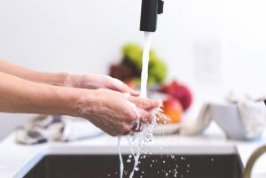 Person washing hands under a tap