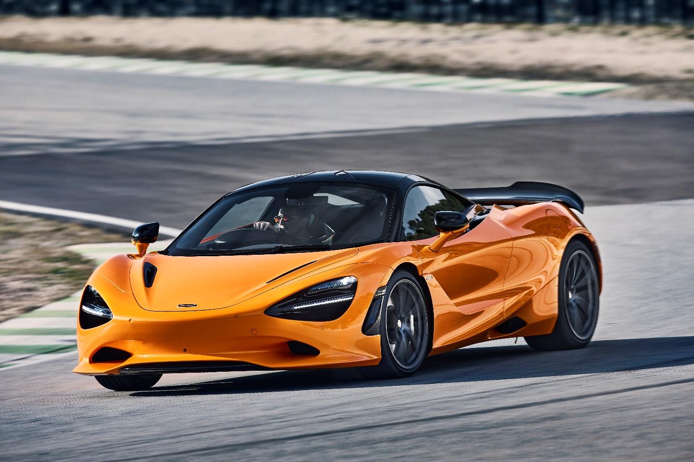 A orange sports car on a race track

Description automatically generated